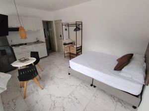a white bedroom with a bed and a table and chairs at Casa Palma Poblado in Medellín