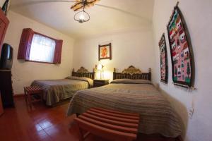 a bedroom with two beds and a window at La Casita de la Basílica in Pátzcuaro +22 photos
