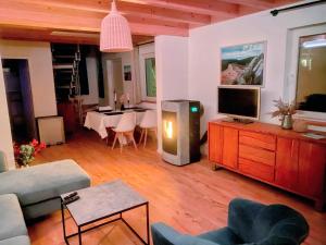 a living room with a tv on a dresser at Schwedenhaus Fridhem mit Panoramablick auf dem Hügel in Monschau +13 photos