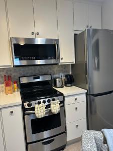 a kitchen with a stove and a stainless steel refrigerator at K STREET CARRIAGE HOUSE Studio in Penticton +13 photos