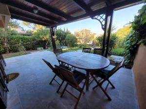 a wooden table and chairs on a patio at Villa il Gabbiano Stintino in Stintino