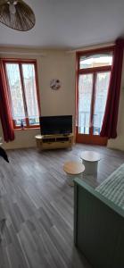 a living room with two tables and a television at Appartement Pierre in Mers-les-Bains