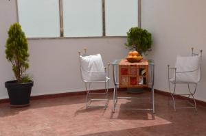 a table with two chairs and a table with oranges on it at Residence 33 bleu in Guelmim