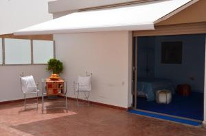 a room with two chairs and a table and a bed at Residence 33 bleu in Guelmim