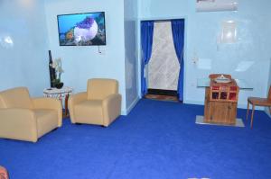 a waiting room with blue carpet and chairs and a door at Residence 33 bleu in Guelmim
