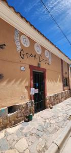 a brown building with writing on the side of it at Gran Casa Hostel&Camping in Tilcara