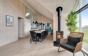a dining room with a table and chairs and a fireplace at Nice Home In Ringkøbing With Sauna in Ringkøbing