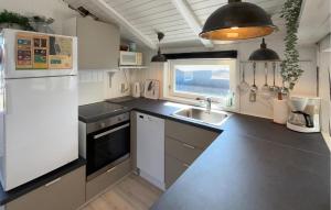 a kitchen with a white refrigerator and a sink at Nice Home In Ringkøbing With Sauna in Ringkøbing
