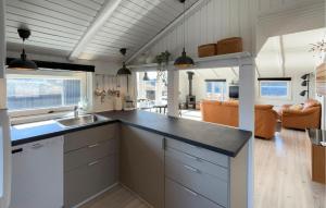 a kitchen with a counter top and a living room at Nice Home In Ringkøbing With Sauna in Ringkøbing