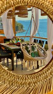 a swing in a room with a table and the ocean at Sunset Coast - Paradise Cottage in Drage
