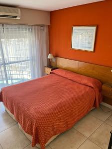 a bedroom with a bed with an orange wall at Maison Apart Hotel in Mar del Plata +27 photos