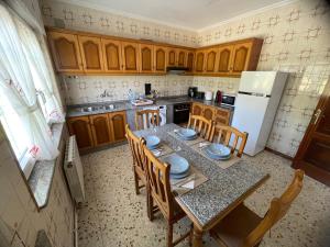 a kitchen with a table and chairs and a refrigerator at O Fogar da Fonte in Cee