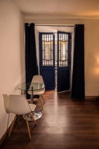 a dining room with a glass table and two chairs at Hotel Ferre Cusco in Cusco