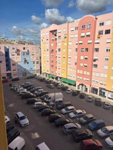 a parking lot with cars parked in front of buildings at Setúbal Sunset Apartment in Setúbal
