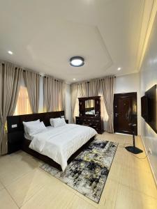 a bedroom with a large bed and a mirror at Klue Homes in Maiyegun