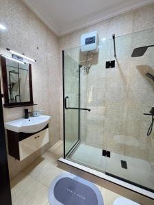 a bathroom with a glass shower and a sink at Klue Homes in Maiyegun