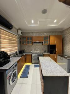 a large kitchen with a washer and dryer in it at Klue Homes in Maiyegun