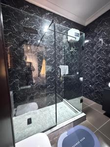 a bathroom with a glass shower with a toilet at Klue Homes in Maiyegun +2 photos