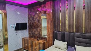 a room with a bed and a mirror and a tv at Yatri room in Varanasi