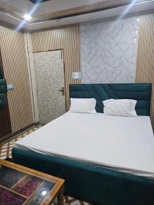 a large bed in a room with a door at Yatri room in Varanasi