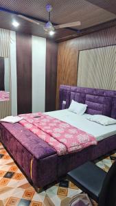 a bedroom with a purple bed in a room at Yatri room in Varanasi +7 photos
