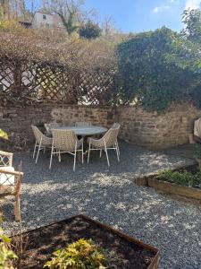 a patio with a table and chairs and a stone wall at EifelQuartier L9 in Schleiden