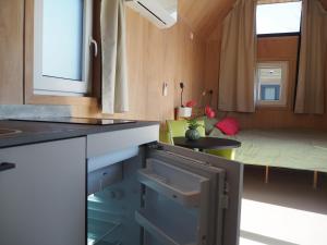 a kitchen with a table and a bed in a room at Buorkerijhûske A - Tussen Wad en Weide in Hallum