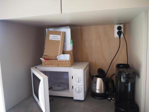 a microwave with a basket on top of it at Buorkerijhûske A - Tussen Wad en Weide in Hallum