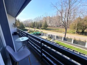 a balcony with a table and chairs and a view of a street at Fifteenapartman in Balatonföldvár