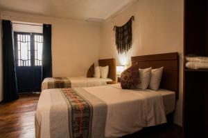 a hotel room with two beds and a window at Hotel Ferre Cusco in Cusco