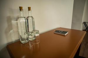 three bottles and glasses sitting on a wooden table at Hotel Ferre Cusco in Cusco +36 photos