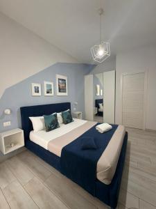 a bedroom with a large bed with a blue headboard at Bilateral B&B in Avola