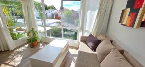 a living room with a couch and a large window at Departamento PH en Martinez in Martínez +34 photos