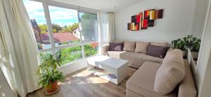 a living room with a couch and a large window at Departamento PH en Martinez in Martínez