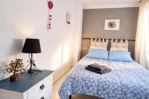a bedroom with a bed and a lamp on a dresser at CASA ADELA - Playa 2 min - Aire Acondicionado - WIFI - Parking cercano in Barbate