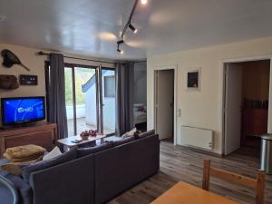 a living room with a couch and a tv at Appartement confortable Dog friendly in Membre
