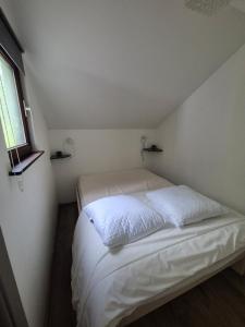 a white bed in a small room with a window at Appartement confortable Dog friendly in Membre