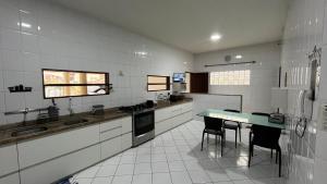 a kitchen with a table and two chairs in it at Casa de praia in São Luís +4 photos