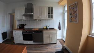 a kitchen with white cabinets and a stove top oven at Ferienwohnung Altes Pfarrhaus in Blumberg