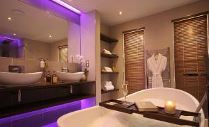 a bathroom with two sinks and a tub and a mirror at Aberdunant Hall, Snowdonia in Porthmadog