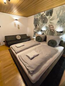 a large bed in a room with a couch at Ferienwohnung Burgperle Burghausen nahe weltlängster Burg zentral 24h Check in in Burghausen