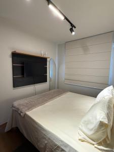 a bedroom with a bed and a window with a television at 098house havana in São Luís