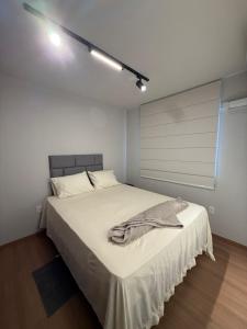 a bedroom with a bed with a blanket on it at 098house havana in São Luís