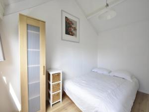 a small bedroom with a bed and a closet at Holiday Home Warmenhuizen near Dunes in Warmenhuizen