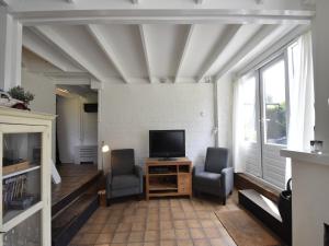 a living room with two chairs and a television at Holiday Home Warmenhuizen near Dunes in Warmenhuizen