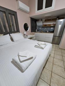 a bedroom with a large white bed with towels on it at Central Apartments in Kardamyli +29 photos