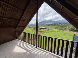 a room with a balcony with a view of the mountains at Cabaña 1 Alajuela, San Carlos, Venecia, Marsella in Pueblo Nuevo