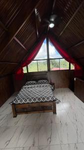 a bedroom with a bed in a roof at Cabaña 1 Alajuela, San Carlos, Venecia, Marsella in Pueblo Nuevo