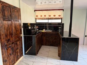a kitchen with a wooden door and a sink at Cabaña 1 Alajuela, San Carlos, Venecia, Marsella in Pueblo Nuevo +7 photos