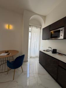 a kitchen with a sink and a table and a microwave at Ippolita Palace LUXURY ROOMS in Otranto
